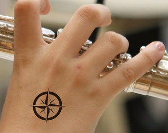 Tatuaje temporal de rosa de los vientos, estilo náutico y aventurero.