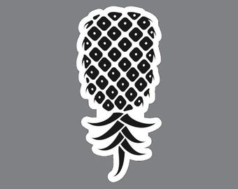 May include: A black and white sticker featuring a stylized pineapple graphic. The pineapple body has a repeating diamond pattern with a central dot in each shape, and the base consists of several pointed, curved leaves in a solid black color.