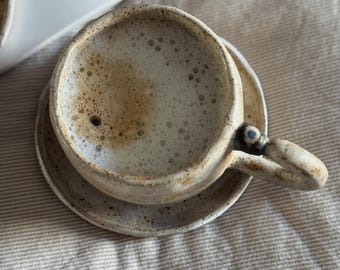 Handgemachte Keramiktasse und Unterteller mit einem gemütlichen einzigartigen bösen Blick | matte weiße Keramik Tasse