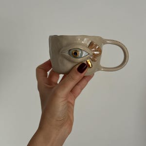 Caneca de cerâmica esculpida à mão em formato de olho • Cerâmica artesanal com brilho dourado