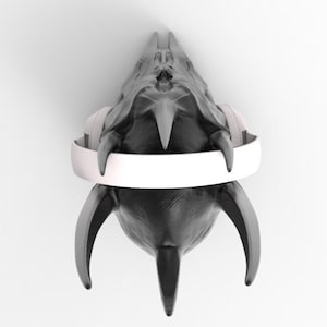 May include: A black skull with sharp, pointed teeth and horns, wearing white headphones. The skull is facing the camera, and the headphones are positioned around the skull's head.