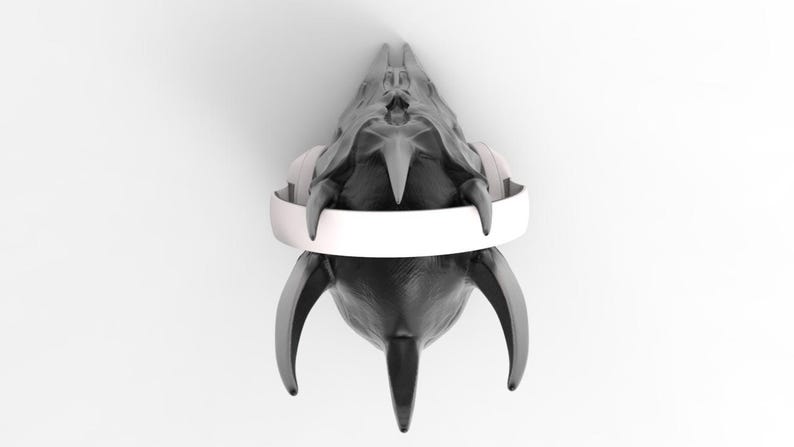 May include: A black skull with sharp, pointed teeth and horns, wearing white headphones. The skull is facing the camera, and the headphones are positioned around the skull's head.