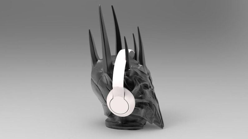May include: A black and gray crown with a white pair of headphones on it. The crown is a replica of the Iron Throne from the Game of Thrones television series.