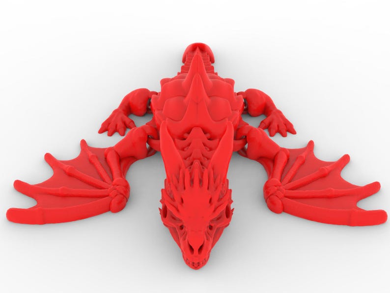 May include: A red dragon figurine with outstretched wings, detailed with sharp spines and a skeletal structure. The dragon is lying on a white surface, showcasing its intricate design and menacing features. The wings are spread wide, ready for flight.