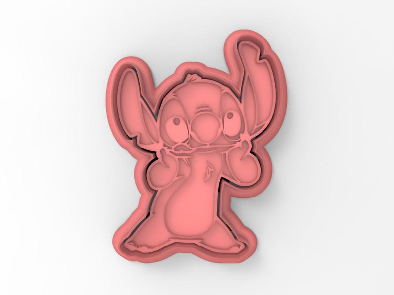 May include: Pink plastic cookie cutter shaped like Stitch from the Disney movie Lilo & Stitch. Stitch is shown with his signature wide eyes and goofy grin.