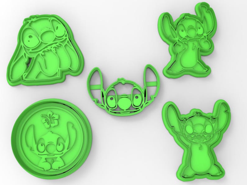 May include: Set of five green plastic cookie cutters shaped like Stitch from the Disney movie Lilo & Stitch. The cutters feature Stitch in different poses, including with his arms raised, with his arms crossed, and with his hands on his hips.