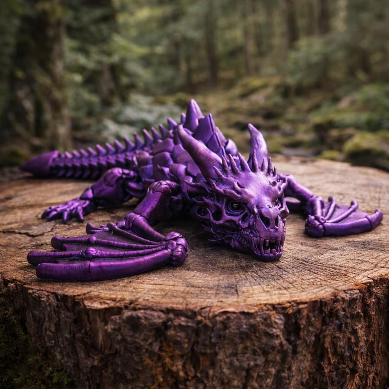 May include: A detailed, purple dragon figurine with intricate scales, horns, and wings, resting on a tree stump. The fantasy creature is posed in a relaxed position, showcasing its detailed design. The background features a blurred forest setting.