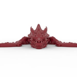 May include: A maroon dragon sculpture with outstretched wings and a detailed, textured surface. The dragon's head is centered, with sharp horns and intricate facial features. The wings extend horizontally, creating a symmetrical design.