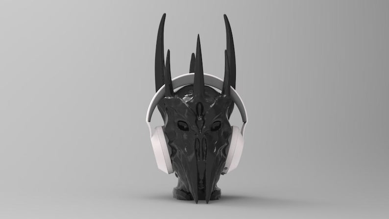 May include: A black and gray helmet with horns, wearing white headphones. The helmet has a detailed design with a face-like structure.