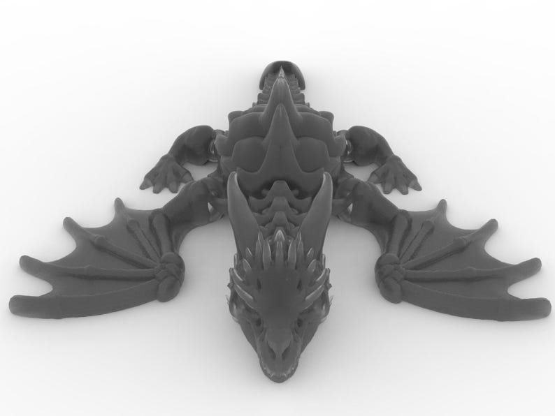 May include: A dark gray dragon figurine with outstretched wings, detailed scales, and a spiked spine. The dragon is lying flat, showcasing its intricate design. The wings are spread wide, and the head is facing forward.
