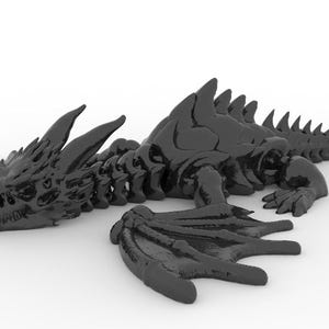 May include: A black dragon figurine with detailed skeletal features, wings, and a long tail. The dragon is lying down on a white surface, showcasing its intricate design and texture. This fantasy-themed sculpture is a decorative item.