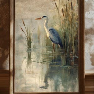 May include: A painting of a grey heron standing in a pond with tall green reeds in the background. The heron has a long neck and a long beak. The water is calm and reflects the sky and the reeds.
