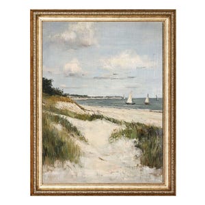 May include: An oil painting of a coastal scene with a sandy path leading to the ocean. The artwork features sailboats on the water, dunes with green grass, and a cloudy sky. The painting is framed in a gold-colored ornate frame.