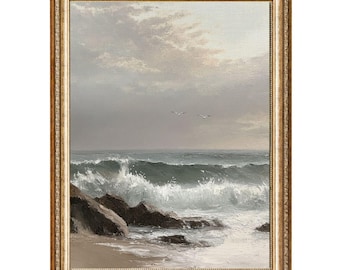 Puede incluir: Pintura enmarcada de un paisaje marino con olas rompiendo y un cielo nublado. La obra presenta una playa arenosa, rocas oscuras y dos pájaros en vuelo. El marco es de color dorado.