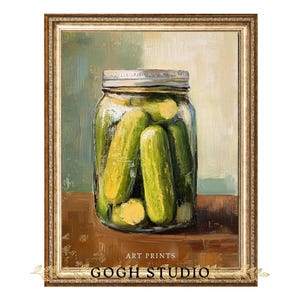 Pode incluir: Uma impressão artística emoldurada com um frasco de picles. Os picles são de um verde vibrante, e o frasco tem uma tampa prateada. A obra de arte é rotulada como "ART PRINTS" e "GOGH STUDIO". A moldura é de uma cor dourada quente.