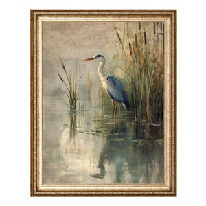 May include: A framed painting of a grey heron standing in a pond with reeds in the background. The heron is facing to the right and has its head turned to the left. The water is a light blue color and the reeds are a light brown color.