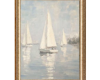 May include: Oil painting of sailboats on the water, framed in a gold-toned ornate frame. The sailboats have white sails and are reflected in the water. The sky is a pale blue with soft brushstrokes.
