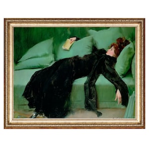 May include: A woman in a black dress lies on a green velvet couch, holding a book. The couch has pillows and is in a room with green walls.