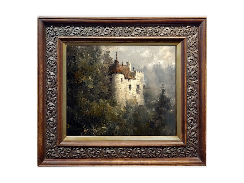 Op de afbeelding: Een ingelijst olieverfschilderij dat een wit kasteel met een rood dak toont, genesteld in een weelderig groen bos. Het kasteel is gedeeltelijk verborgen door bomen en de achtergrond is een wazige blauwe lucht.