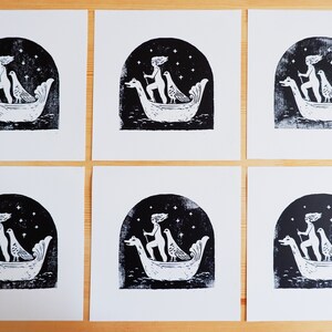 Peut inclure: Six estampes en noir et blanc d'une femme dans un bateau avec deux oiseaux. La femme tient un b&acirc;ton et les oiseaux sont perch&eacute;s sur le bord du bateau. L'arri&egrave;re-plan est un ciel sombre avec des &eacute;toiles.