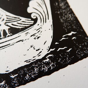 Peut inclure: Gravure sur linol&eacute;um en noir et blanc d'un oiseau dans un bateau sur une mer ondul&eacute;e. L'impression est sur papier blanc.