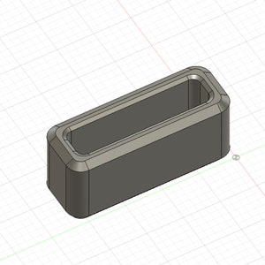 May include: A gray plastic rectangular block with a rectangular opening in the center. The block is designed to be used as a connector or a spacer.