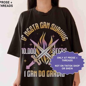 May include: Black t-shirt with the text "IF NESTA CAN SURVIVE 10,000 STEPS I CAN DO CARDIO" in a stylized font. The design includes crossed swords and a flame-like graphic. The shirt also has the text "ONLY AT PROSE + THREADS" and "NOT ON TIKTOK SHOP OR SHEIN".