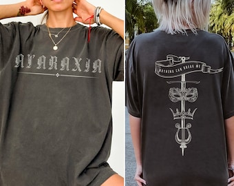May include: Two gray t-shirts with different designs. The first shirt has the text "AJARAXJA" printed on the front. The second shirt has a sword, crown, and lyre design with the text "NOTHING CAN BREAK ME" printed on the back.