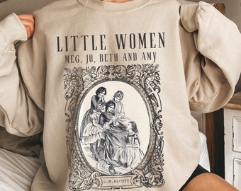 Könnte beinhalten: Ein beiger Pullover mit einer Vintage-Illustration von vier Mädchen aus dem Buch "Little Women" von Louisa May Alcott. Der Text "Little Women" und "Meg, Jo, Beth and Amy" ist auf dem Pullover aufgedruckt.