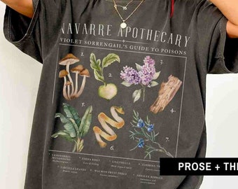 Peut inclure: Un t-shirt gris foncé avec un imprimé graphique vintage d'illustrations botaniques et le texte "NAVARRE APOTHECARY VIOLET SORRENGAIL'S GUIDE TO POISONS".