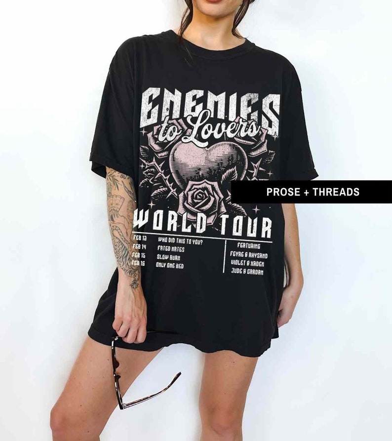 Pode incluir: Camiseta preta com uma estampa gr&aacute;fica branca de um cora&ccedil;&atilde;o com espinhos e uma rosa. O texto "Enemies to Lovers World Tour" est&aacute; impresso na camiseta. As datas da turn&ecirc; e os artistas em destaque est&atilde;o listados abaixo do gr&aacute;fico.