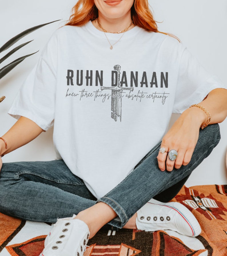 May include: White t-shirt with a black graphic print of a sword and the text "RUHN DANAAN knew three things with absolute certainty".