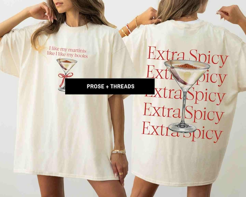 May include: Cream-colored t-shirt with a martini graphic and the text "I like my martinis like I like my books" on the front. The back of the shirt features a martini graphic and the words "Extra Spicy" repeated. The brand name "PROSE + THREADS" is also visible.