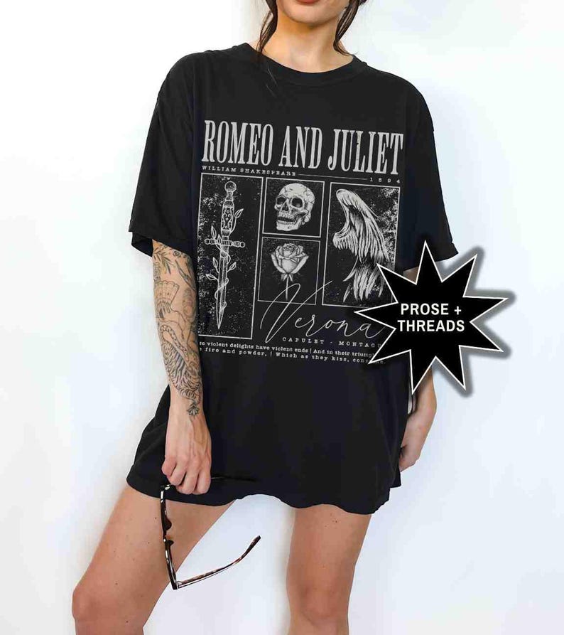 May include: Black t-shirt featuring a graphic design from Shakespeare's "Romeo and Juliet." The design includes a dagger, skull, rose, and angel wings. The word "Verona" is also featured. The shirt also has the text "PROSE + THREADS."