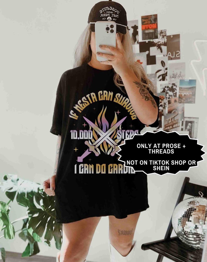 May include: Black t-shirt with the text "IF NESTA CAN SURVIVE 10,000 STEPS I CAN DO CARDIO" and a graphic of crossed swords and flames. The shirt also has the text "ONLY AT PROSE + THREADS NOT ON TIKTOK SHOP OR SHEIN".
