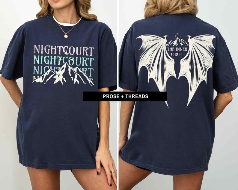 May include: Two navy blue t-shirts with different graphic designs. The first shirt features a mountain range with the text "NIGHTCOURT NIGHTCOURT NIGHTCOURT". The second shirt features a pair of wings with the text "THE INNER CIRCLE".