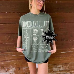 May include: Olive green t-shirt featuring the text "ROMEO AND JULIET" above a graphic design with a skull, rose, and sword. The shirt also includes the text "Verona" and "PROSE + THREADS".