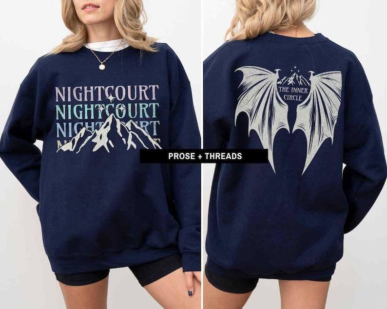 May include: A navy blue sweatshirt with a graphic of mountains and the text "NIGHTCOURT NIGHTCOURT NIGHTCOURT" on the front. The back of the sweatshirt has a graphic of wings with the text "THE INNER CIRCLE" in a circle.