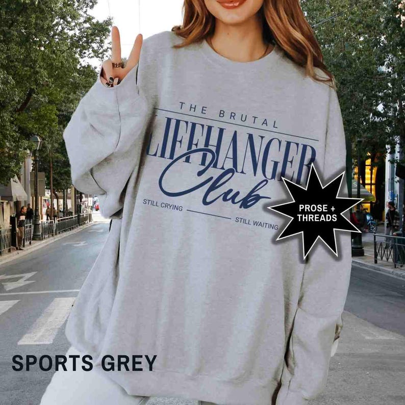 Puede incluir: Una sudadera gris con el texto "The Brutal Lifehanger Club" en azul. El texto "Still Crying" y "Still Waiting" est&aacute; impreso debajo del texto principal. Una estrella negra con el texto "Prose + Threads" est&aacute; en la esquina inferior derecha. La sudadera est&aacute; etiquetada como "Sports Grey".