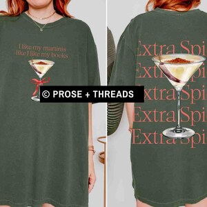 May include: Olive green t-shirt with a martini graphic and the text "I like my martinis like I like my books" on the front. The back of the shirt features a martini graphic and the words "Extra Spicy".