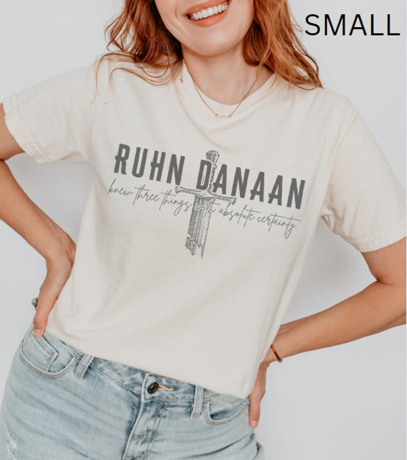 May include: A cream coloured t-shirt with a graphic of a sword and the text "Ruhn Danaan knew three things with absolute certainty".