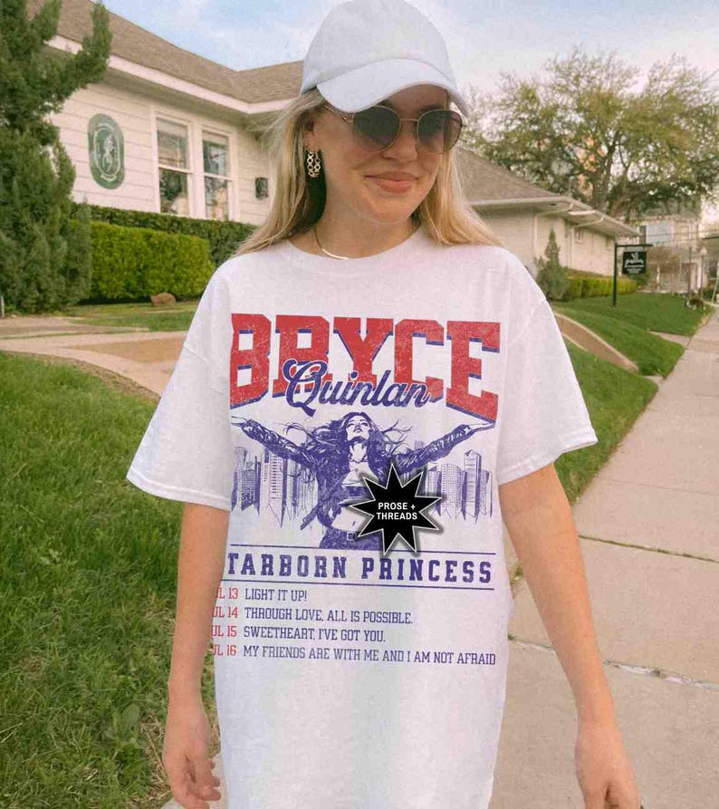 May include: White t-shirt featuring a graphic print of a woman with the text "Bryce Quinlan" and "Starborn Princess". The graphic also includes the text "Prose + Threads".