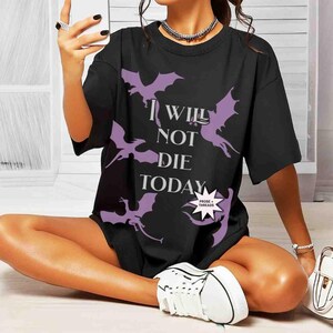May include: Black oversized t-shirt with a graphic print of purple dragons and the text "I Will Not Die Today".