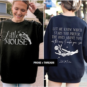 May include: Black sweatshirt with the text "Little Mouse" and a graphic of a skeleton hand holding a rose. The back of the sweatshirt is navy blue with the text "Let me know which stars you prefer..." and a similar graphic.