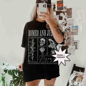 May include: Black t-shirt featuring a graphic design from Shakespeare's "Romeo and Juliet." The design includes a sword, skull, rose, and angel wings. The text "Verona" and a quote are also visible.