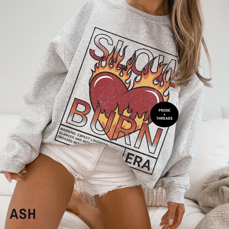 May include: Gray sweatshirt with a graphic print of a heart on fire with the text "Slow Burn Era" and "Prose + Threads".