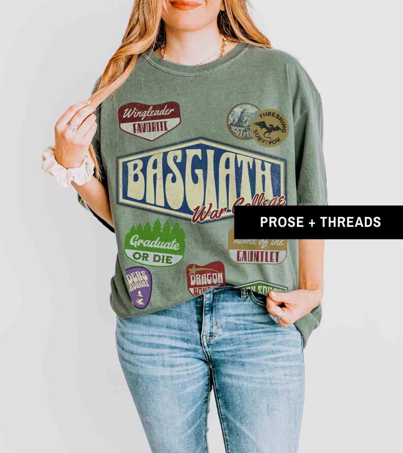 May include: Green t-shirt with a graphic print of a college logo, "Basgaath War College", and various patches, including "Wingleader Favorite", "Thresing Survivor", "Graduate or Die", "Home of the Gauntlet", "Dragon Bone", and "Ders Oklahoma".
