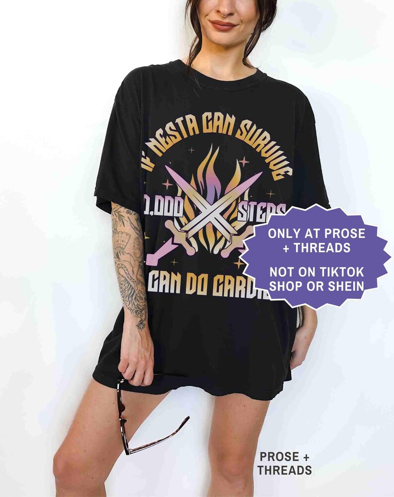 May include: Black t-shirt with the text "IF NESTA CAN SURVIVE 1,000 STEPS CAN DO GARD". The design includes crossed swords and a flame graphic. The shirt also has the text "ONLY AT PROSE + THREADS" and "NOT ON TIKTOK SHOP OR SHEIN".