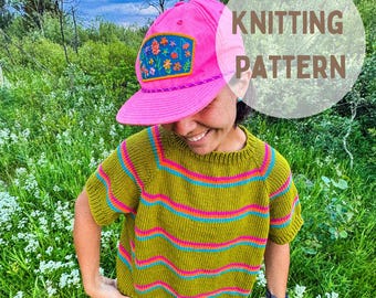 Puede incluir: Una persona con una gorra rosa con un parche floral y un suéter verde y a rayas de manga corta. El texto "KNITTING PATTERN" está en un círculo blanco en el fondo. El suéter tiene rayas horizontales rosas y azules.