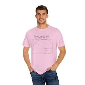 Könnte beinhalten: Ein pinkfarbenes T-Shirt mit einer schwarzen Grafik einer Fibonacci-Spirale und dem Text "Fibonacci Sequence - Spiral 0, 1, 1, 2, 3, 5, 8, 13, 21, 34,..."
